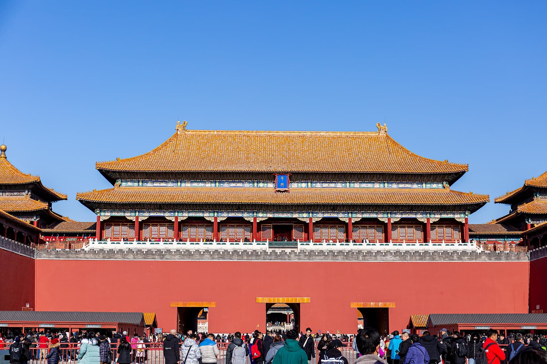 The red walls and five pavilions of the Meridian Gate, the south entrance of the Forbidden City, with visitors gathering in front