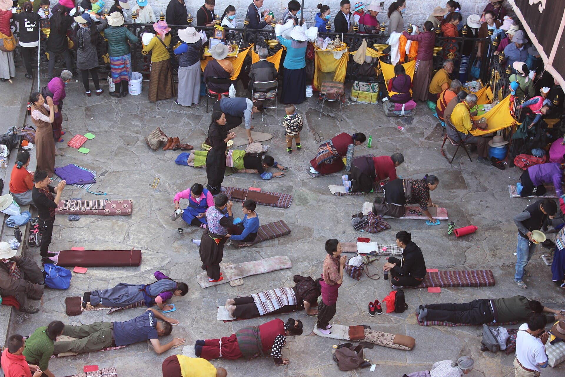 Pilgrims prostrating on mats and boards in front of the Jokhang Temple in Lhasa