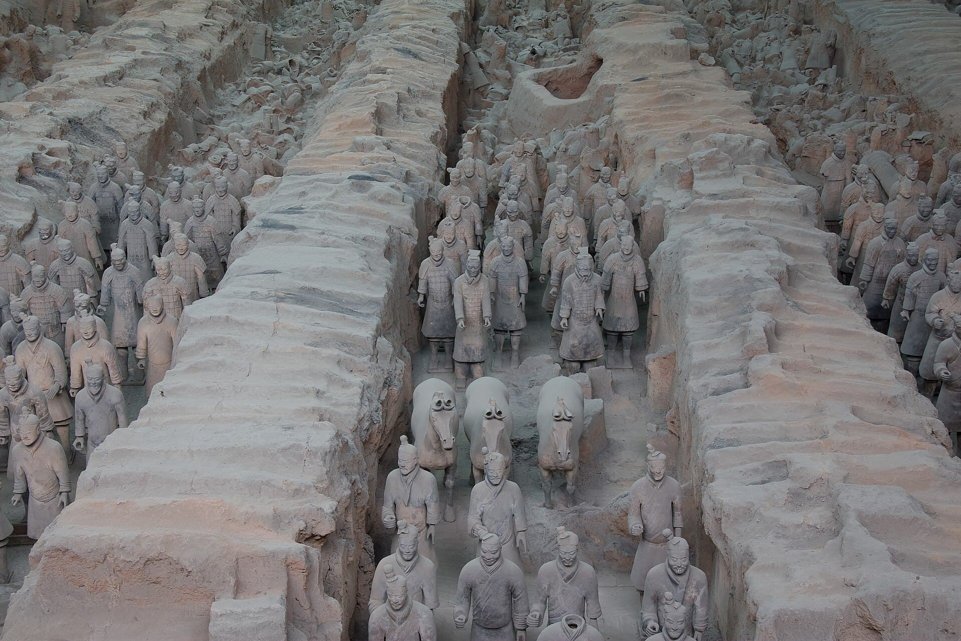 Rows of life-size terracotta soldiers standing in the earthen corridors of Pit 1, seen from the viewing gallery
