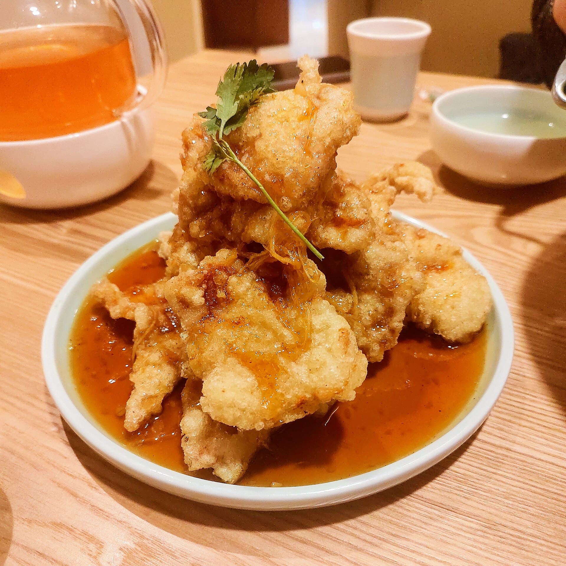 A plate of guobaorou, crisp fried pork slices in a glossy sweet and sour sauce
