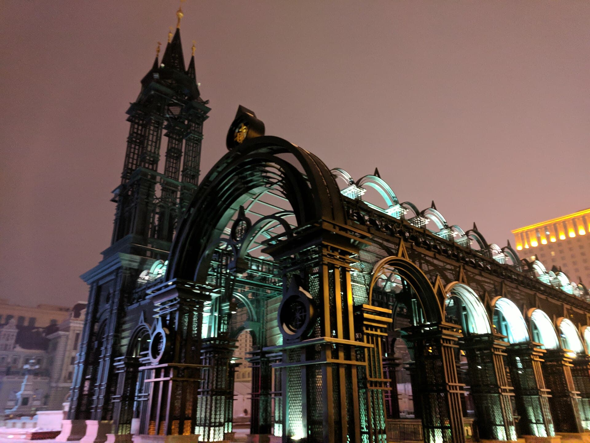 St Sophia Cathedral in Harbin at night in winter, its green onion dome and red brick walls lit against a dark sky
